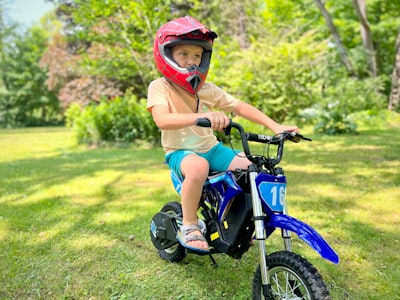 a young boy riding a small blue dirt bike