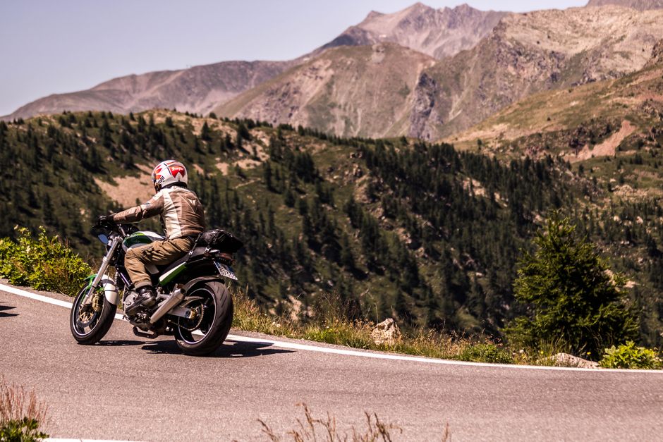 A motorcyclist cruises through the scenic roads of Italy's mountainous landscape, enjoying the adventure and freedom.